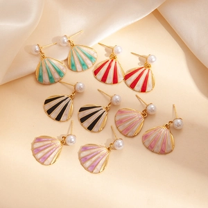 Detail view of colorful shell earrings with gold plating and artificial pearls