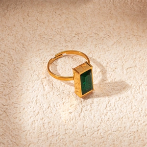 Detail of emerald cut green gemstone on a vintage style golden adjustable ring