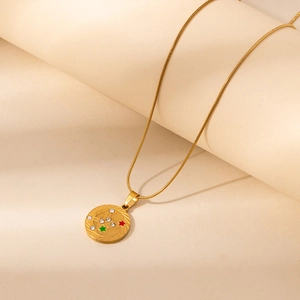 Detail of gold zodiac pendant with star enamel and cubic zirconia on snake chain