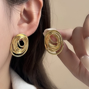 Detailaufnahme der hochglanzpolierten Gold-Spiralohrringe für Damen am Modell