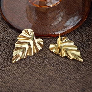 Makroaufnahme goldener Blattohrringe mit Metallexur und Details zum Ohrstecker