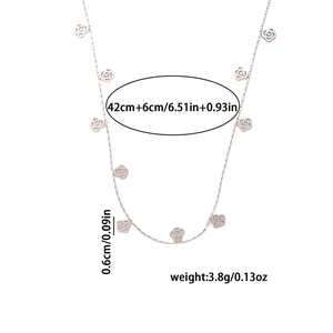 Detail view of silver stainless steel necklace featuring small rose flower pendants