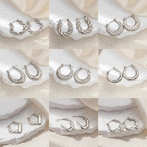 Elegant collection of nine silver stainless steel hoop earrings in various minimalist designs