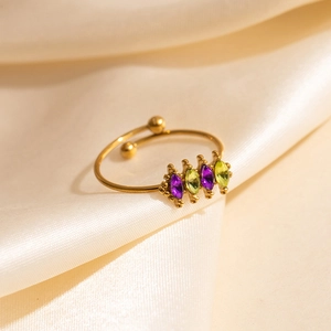 Gold open ring with four marquise-cut purple and green zircons on beige satin