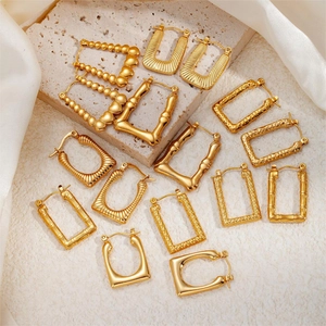 Detail of luxury gold twisted earrings with geometric patterns on elegant silk