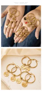 Detailed view of gold stainless steel hoop earrings with star, butterfly and heart charms