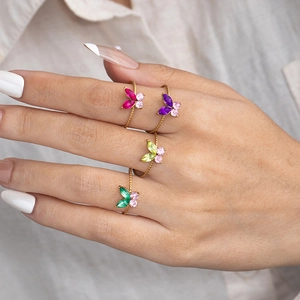 Elegant gold butterfly rings with colorful zircon crystals set on a feminine hand