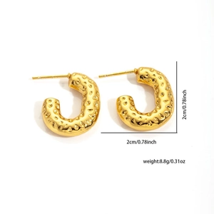 Detailed view of golden C-shaped twisted earrings with a hammer texture finish