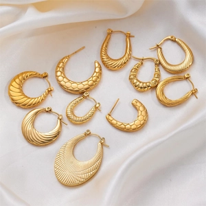 Elegant gold titanium steel twist hoop earrings set on white silk background