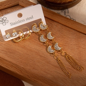 Détail d'un ensemble de boucles d'oreilles en acier avec pampilles lune et clous en zircon