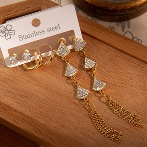 Détail d'un ensemble de boucles d'oreilles en acier doré avec glands en éventail