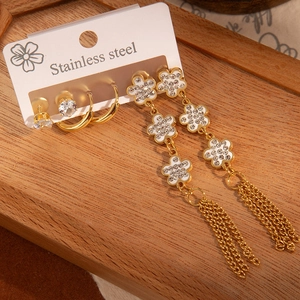 Détail d'un ensemble de boucles d'oreilles en acier inoxydable avec glands et fleurs
