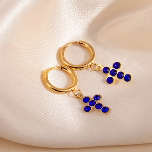 Goldene Creolen mit Kreuzanhängern, besetzt mit funkelnden tiefblauen Kristallsteinen