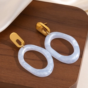 Boucles d'oreilles ovales dorées avec résine à motif de marbre bleu clair sur soie