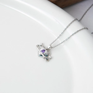 Minimalist planet heart necklace with purple gemstone and star detail on white ceramic plate