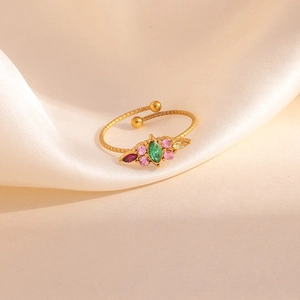 Détail macro d'une bague dorée réglable avec des zircons colorés en forme de trèfle
