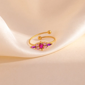Vue détaillée d'une bague trèfle dorée avec zircons roses sur fond de soie douce