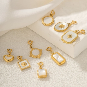 Set of seven gold plated alloy pendants with white shell inlay and spring clasps for jewelry