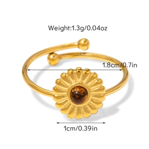 Détail d'une bague vintage réglable avec pierre oeil de tigre et motif floral en soleil