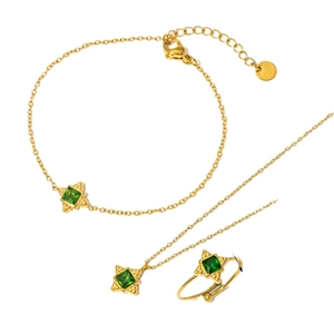 Three-piece gold jewelry set with emerald green stones featuring necklace, ring, and bracelet