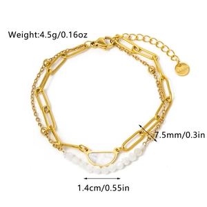Detail of gold double-layer stainless steel bracelet with white shell pendant and beads