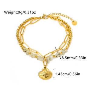 Macro detail of gold double-layer bracelet with natural green stone and shell pendant