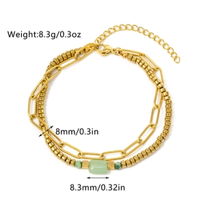 Detailed view of double-layer gold paperclip chain and green stone bracelet charms