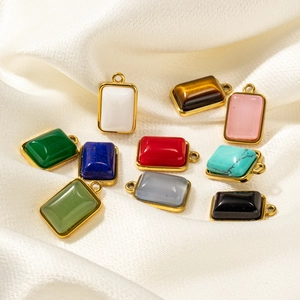 Colgantes rectangulares de piedra natural con borde de acero dorado sobre seda blanca