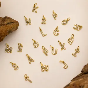 Macro shot of gold-plated alphabet pendants with crystal stones for DIY jewelry