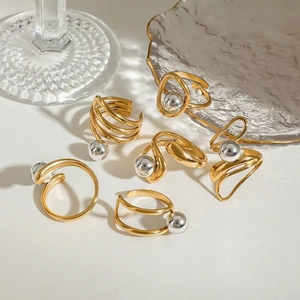 Detailed close-up of mixed metal gold ring bands with silver bead accents on white glass
