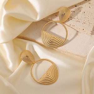 French vintage gold drop earrings with textured circles on silk and stone background