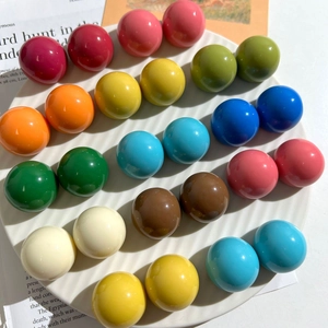 Primo piano di perle tonde in resina Morandi colorate in un piatto di ceramica bianco
