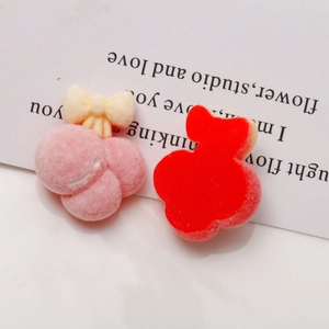 Dettaglio di accessori per capelli in peluche floccato con motivi floreali rosa e rossi