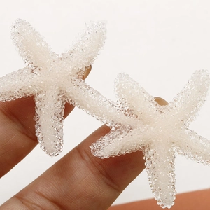 Makrofoto von lichtdurchlässigen weißen Seestern-Anhängern mit Zuckertextur für DIY