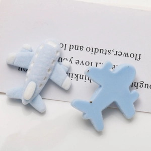Dettaglio macro dell'accessorio per capelli fai da te a forma di aereo blu floccato