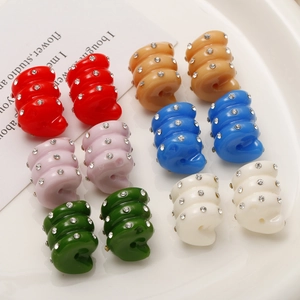 Macro shot of colorful spiral resin beads with inlaid rhinestones for DIY jewelry making