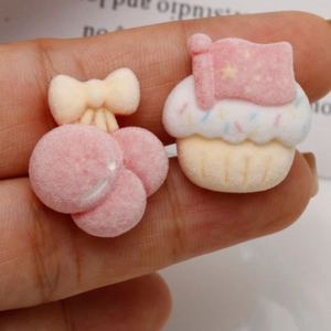Dettaglio di accessori fai-da-te in velluto rosa con ciliegie e cupcake floccati