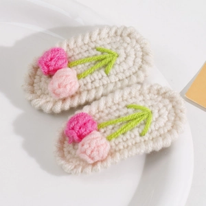 Detailaufnahme handgefertigter Häkel-Tulpen-Haarspangen mit rosa Knospen und grünen Blättern