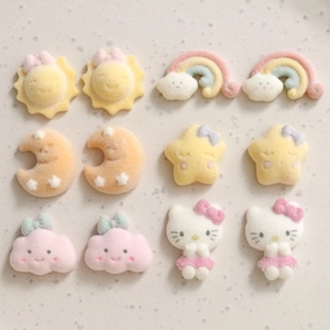 Close-up of macaron-colored flocked hair clips featuring sun, moon, and star designs