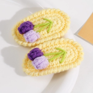 Nahaufnahme handgefertigter Häkel-Haarspangen mit Tulpenmotiv in Gelb und Lila