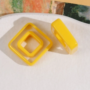 Detailed macro view of yellow nested square resin charms for DIY hair accessories