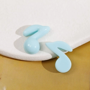 Vista macro di ciondoli a nota musicale in resina azzurro per accessori fai-da-te e bijoux