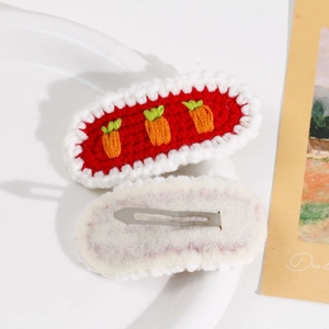 Detail of handmade knit carrot hair clips with delicate white wavy lace edges