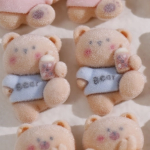 Macro view of cute flocked bear charms holding bubble milk tea for DIY jewelry