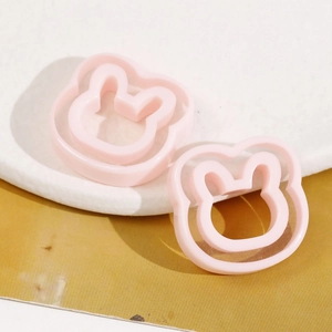 Detail of two pink rabbit-shaped resin accessories for DIY jewelry and hair clips