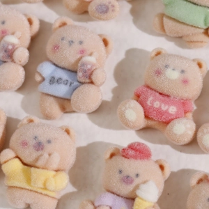 Macro shot of cute flocked bear DIY charms in pastel colors for handmade accessories