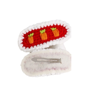 Handmade knitted carrot hair clip with red yarn body and white lace border on white background