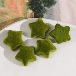 Primer plano de cinco estrellas flocadas verdes para accesorios de cabello DIY en un plato