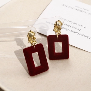 Detail of burgundy flocked rectangular earring pendants with gold textured metal studs