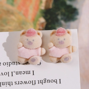 Detailed close-up of pair of beige flocked bears with pink outfits for DIY accessories
